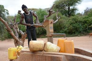 A member of the Wasya Wa Athi B self-help group, southeast Kenya, pumps clean water from a shallow well